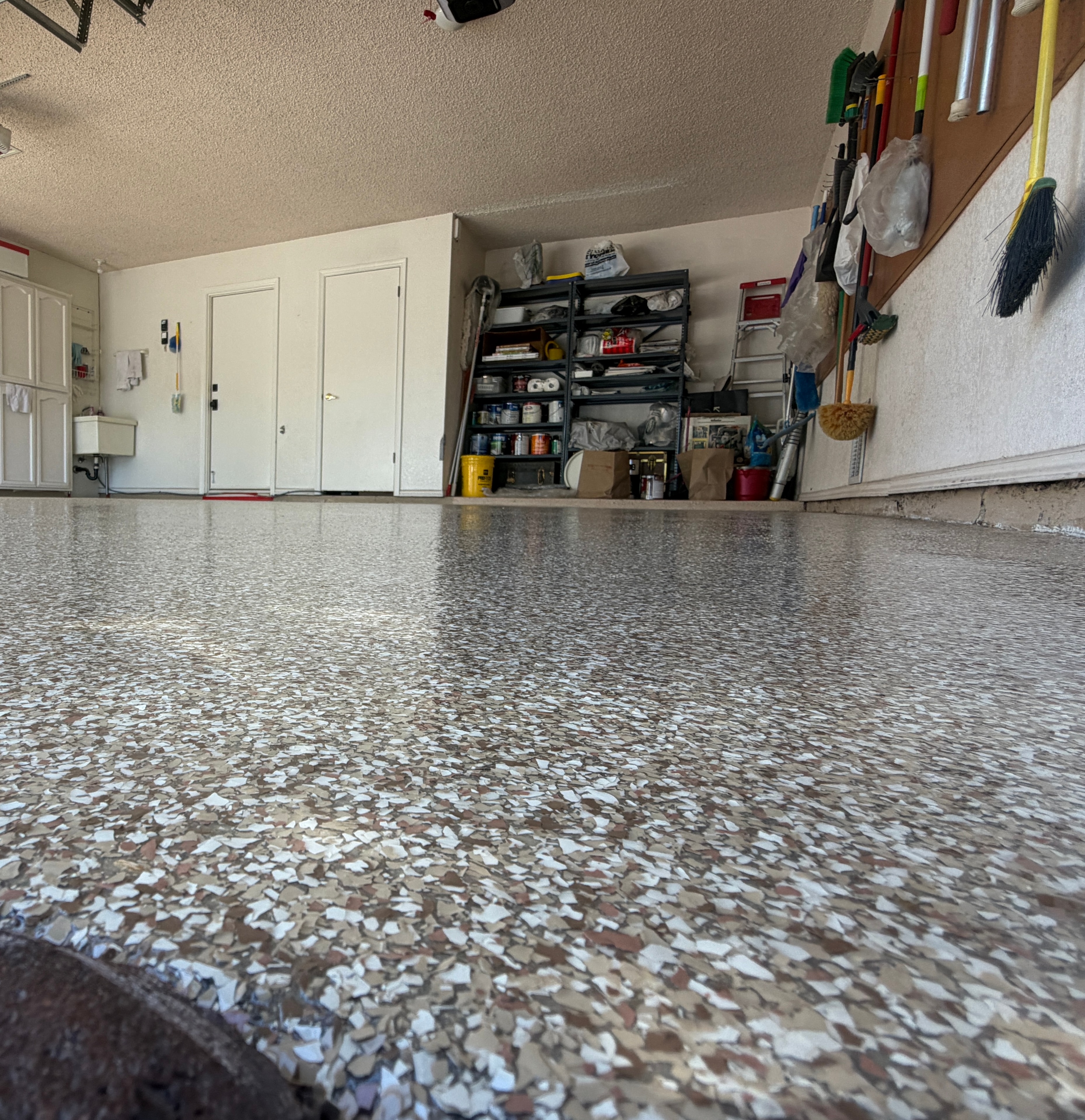Desert Tumbleweed Flake — Low Angle — Desert Tumbleweed full-chip flake system with polyaspartic topcoat. Warm earth tones with high-gloss finish. Arizona.